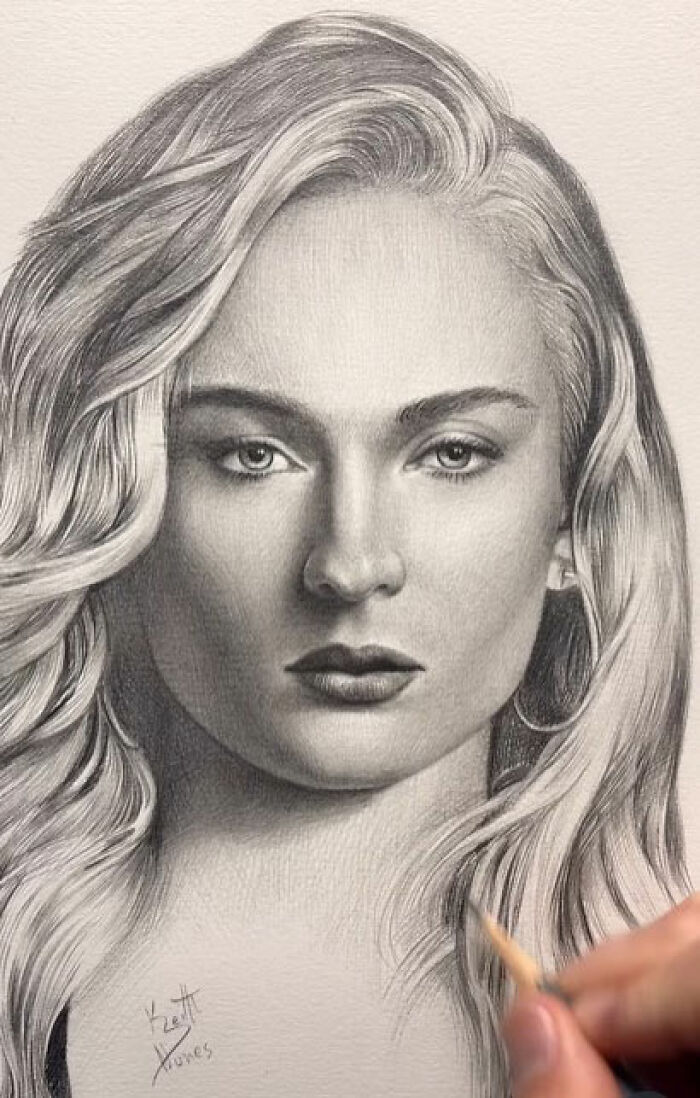 Hand drawing a detailed pencil portrait of a woman with flowing hair, capturing every tiny detail in the artwork.