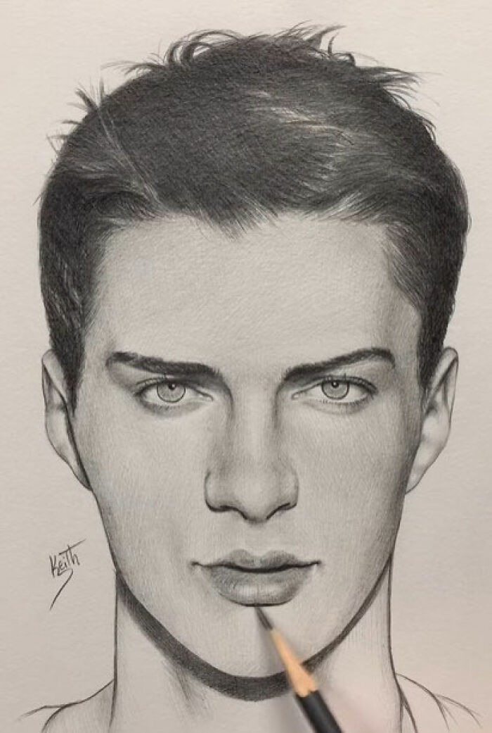 Realistic pencil portrait of a young man with detailed facial features and textured hair being drawn by an artist’s hand.