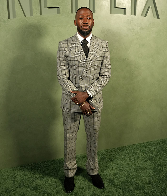 Man wearing a double-breasted grey plaid suit and black tie, showcasing a celebrity outfit that caught attention at Emmys after parties.