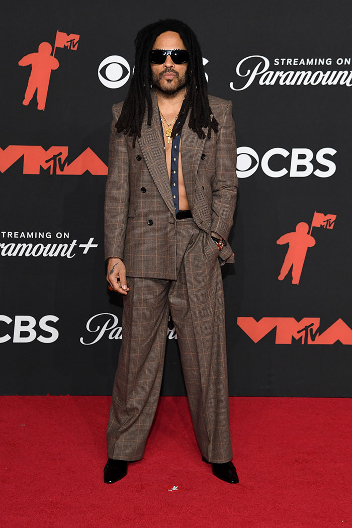 Male celebrity with dreadlocks wearing a plaid suit and sunglasses, showcasing stunning celebrity looks at the 2025 MTV VMAs.