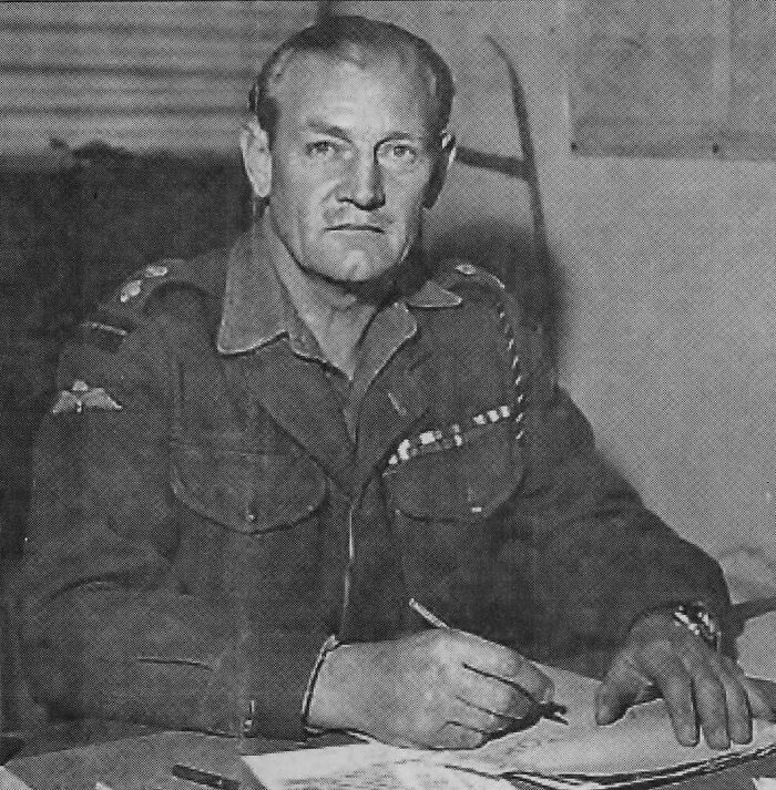 Black and white photo of a military officer writing at a desk, illustrating real life more interesting and bizarre than fiction.