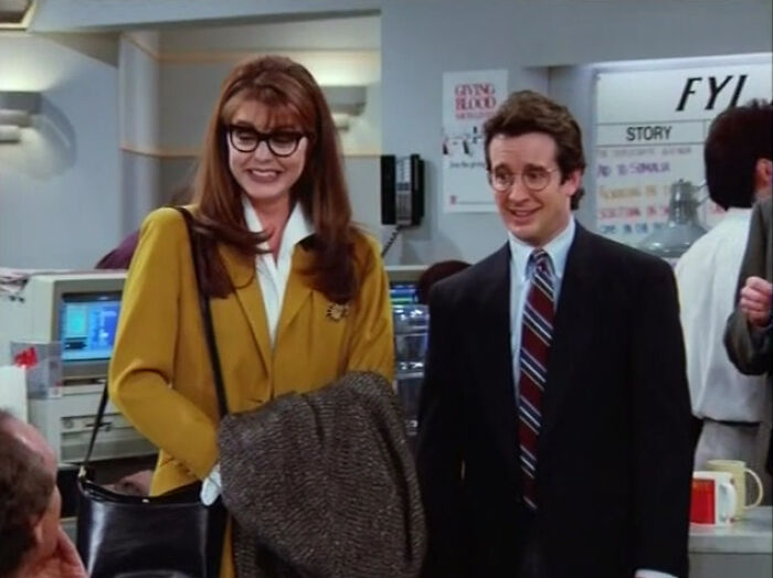 Two well-dressed individuals in an office setting representing well-written female characters in movies breaking stereotypes.