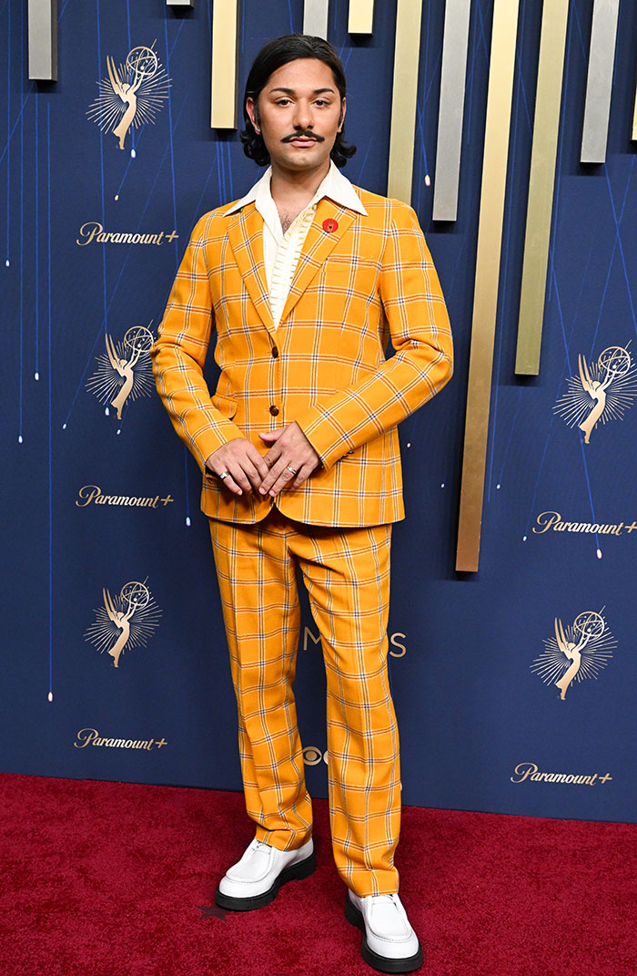 Person wearing a bright yellow plaid suit with white shoes on the red carpet showcasing Emmy fashion highlights.