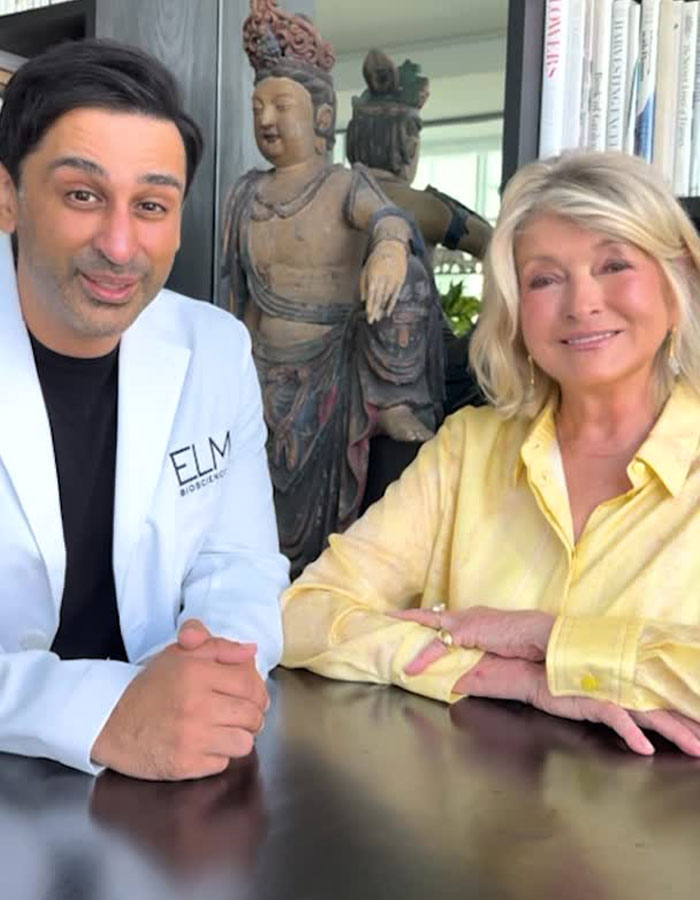 Martha Stewart sitting with a man in a white coat, sparking plastic surgery rumors in a casual indoor setting.