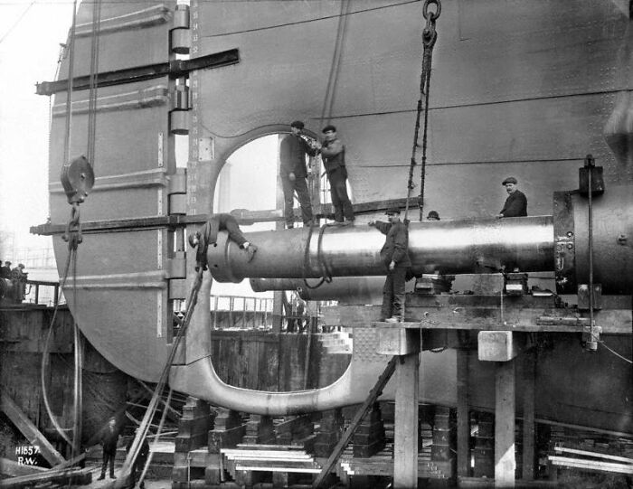 Crew members installing the rudder of the Titanic during construction in a rare historical photo from the early 1900s.