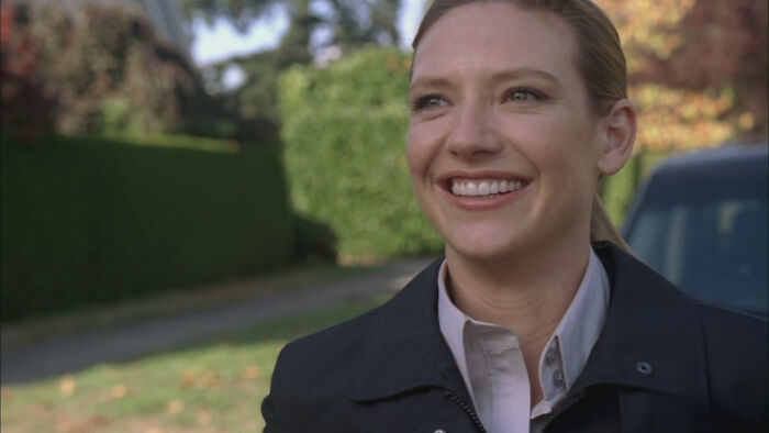 Smiling female character from a movie scene representing well-written female characters breaking stereotypes.