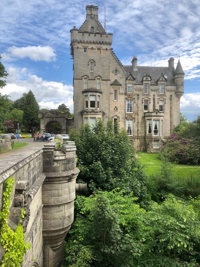 Historic castle surrounded by lush greenery and stone bridge, one of the photos that seem normal until you learn the mysteries behind.