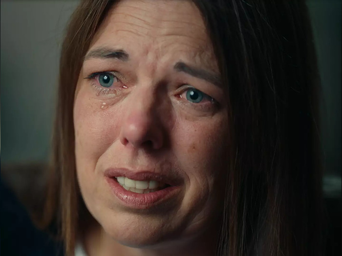 Close-up of a distressed woman with tears, related to an expert explaining a mom who catfished her daughter using Lo nickname.