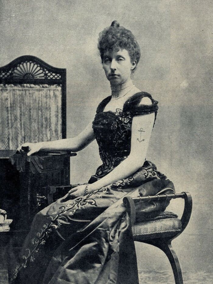 Victorian woman in elegant dress with visible arm tattoo, illustrating bizarre and creepy Victorian facts from the era.