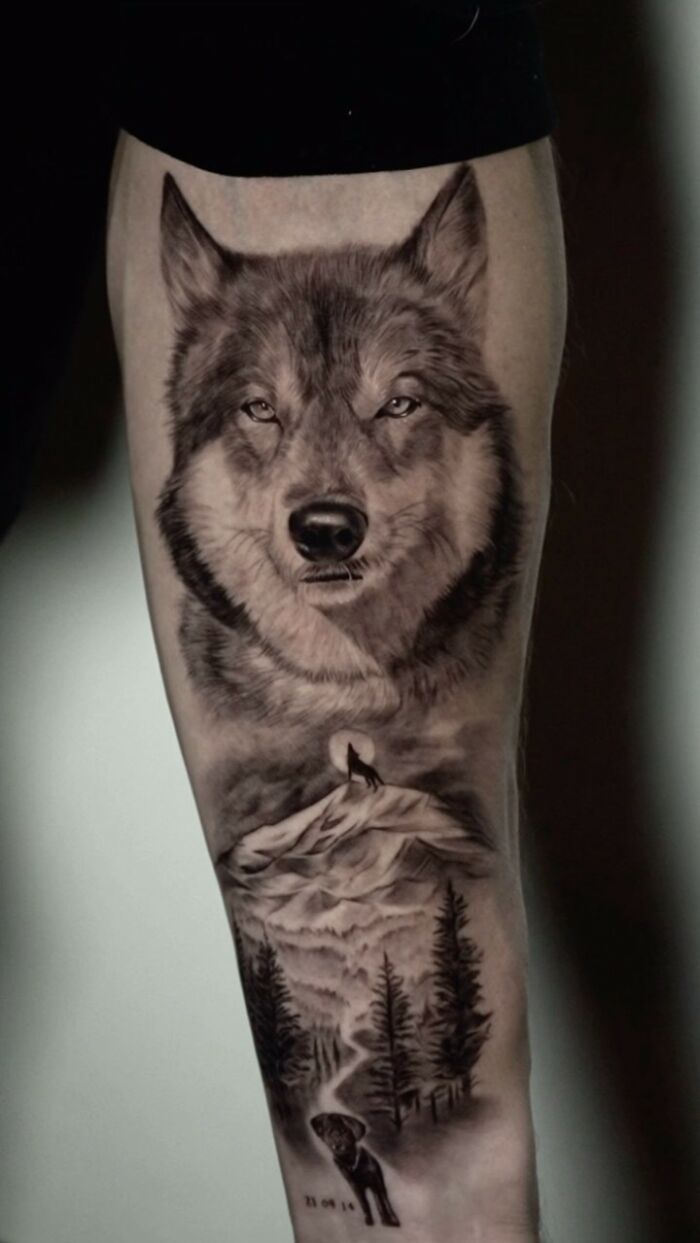 Realistic black and grey wolf tattoo on forearm with mountain and forest landscape, emotional pet tattoos by Korean artist