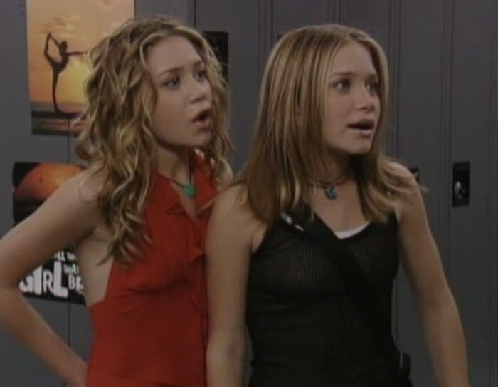 Mary-Kate and Ashley Olsen in casual outfits, looking surprised and unrecognizable at a fashion event. Mary-Kate and Ashley Olsen in casual outfits, looking surprised and unrecognizable at a fashion event.