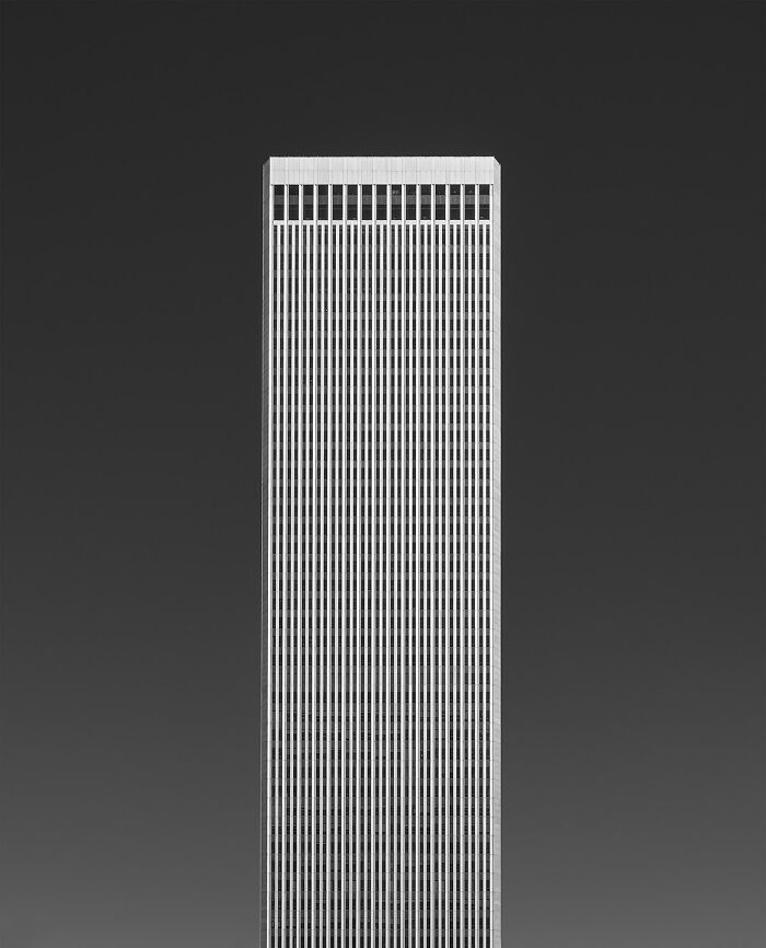 Minimalism captured in stunning black and white photo of a tall, rectangular modern building against a clear sky.