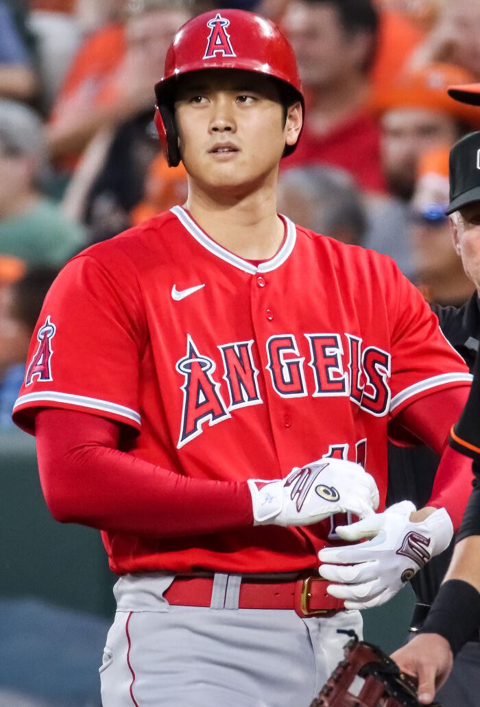 Baseball player in red Angels uniform preparing to bat, featured among highest paid athletes in 2025 photos.