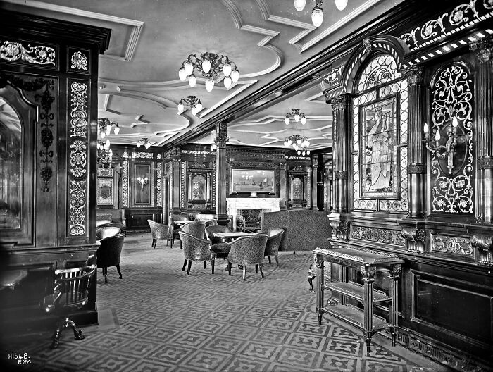 Rare historical photo of the Titanic's luxurious interior lounge with ornate woodwork and elegant furnishings.