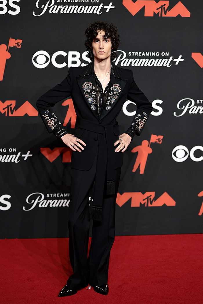 Young celebrity in embellished black suit posing on the red carpet at the 2025 MTV Video Music Awards stunning looks