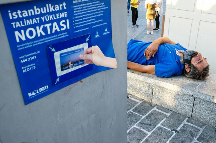 Man lying on a low stone wall in bright sunlight, wearing a blue shirt and a protective face mask.