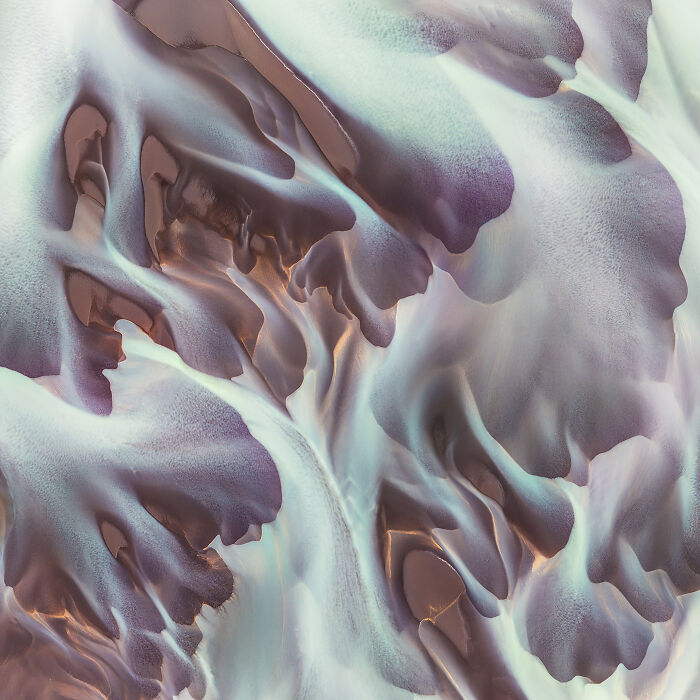 Abstract aerial view of natural formations with smooth curves and soft colors capturing minimalism in nature.