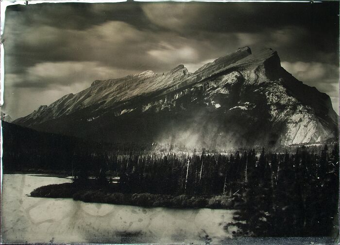 Analog photo of a dramatic mountain landscape with dark clouds, showcasing the best of film photography.