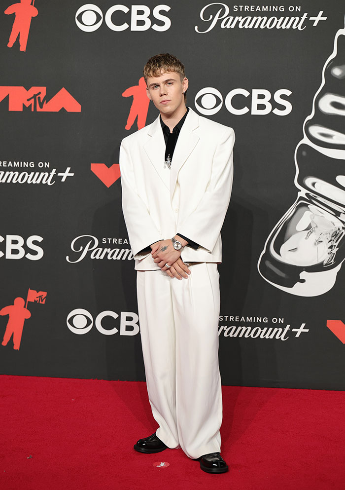 Celebrity in a white suit posing on the red carpet showcasing stunning looks at the 2025 MTV Video Music Awards.