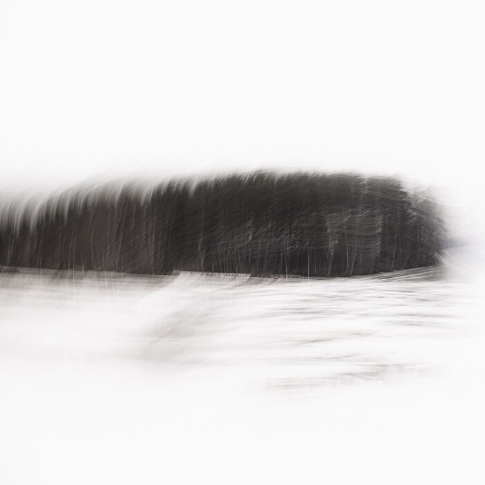 Blurred minimalist landscape with dark trees and snow, capturing the essence of stunning minimalism photography.