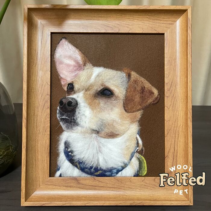 Wool felt pet portrait of a dog with realistic fur texture, capturing lifelike details in a wooden frame.