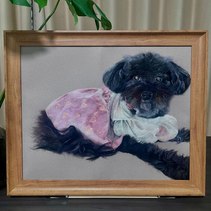 Framed wool felt pet art of a black dog wearing a pink dress, crafted to look incredibly realistic and lifelike.