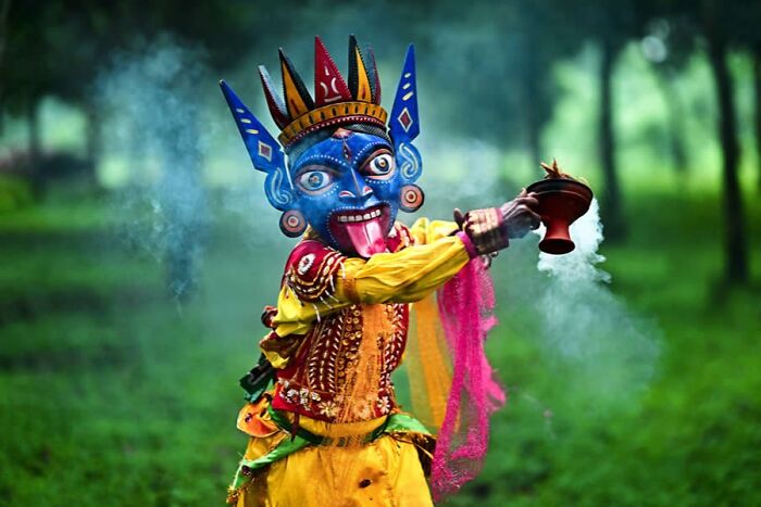 Colorful traditional mask and costume emitting smoke in a stunning photo featured on a popular Instagram page.