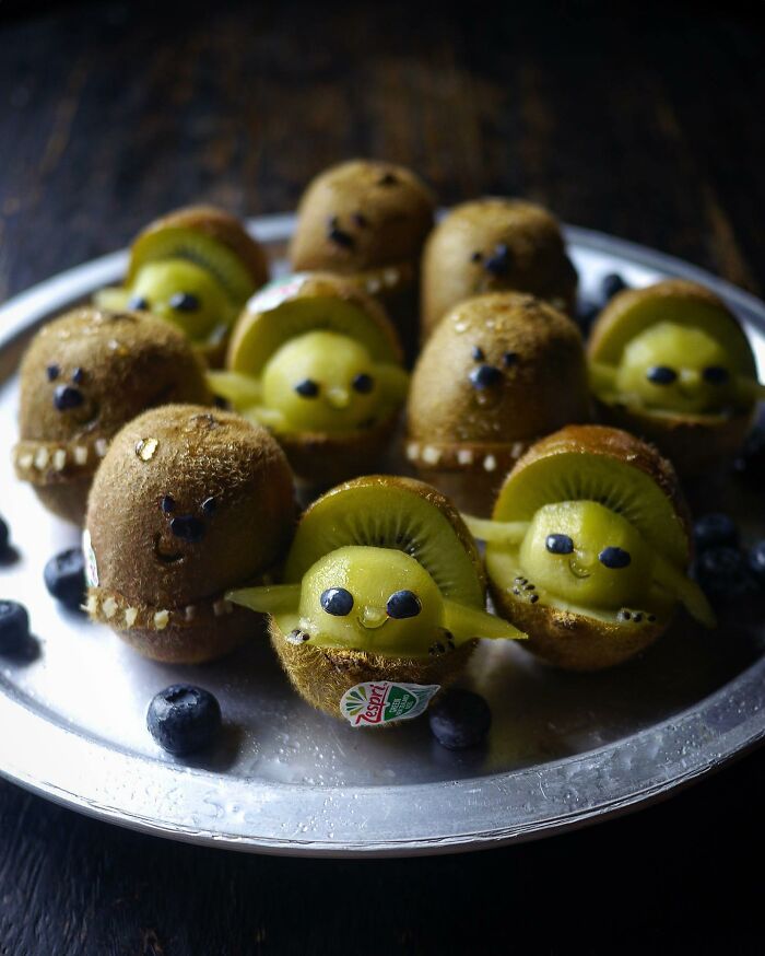 Creative meals for kids featuring kiwi crafted into adorable animal shapes on a silver tray with blueberries around.