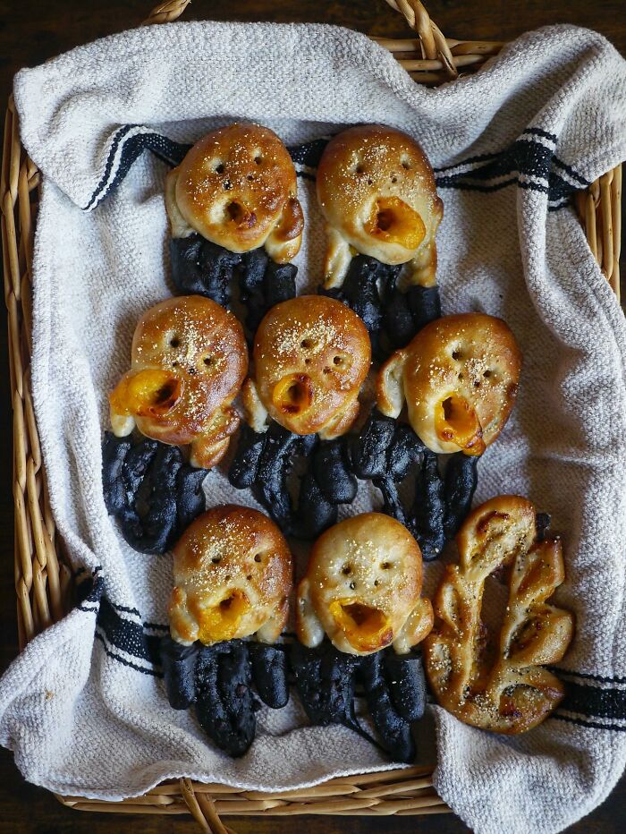 Basket of creative homemade bread shaped like expressive faces with black and golden brown dough, inspired by Japanese kids' meals.