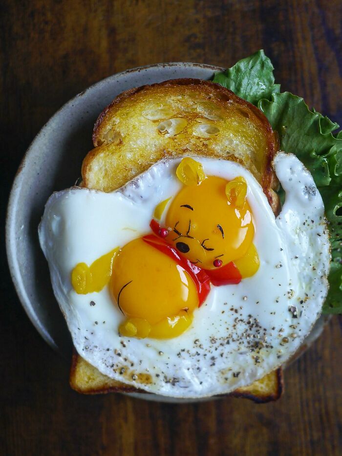 Creative meal featuring a sunny-side egg styled like a cartoon character on toast with lettuce, showcasing kid-friendly food art.