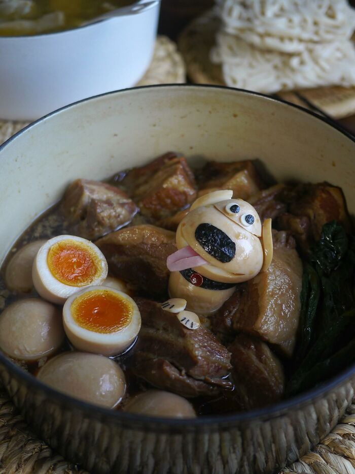 Creative Japanese kids meal featuring a cute dog-shaped egg decoration with meat and soft-boiled eggs in a bowl.