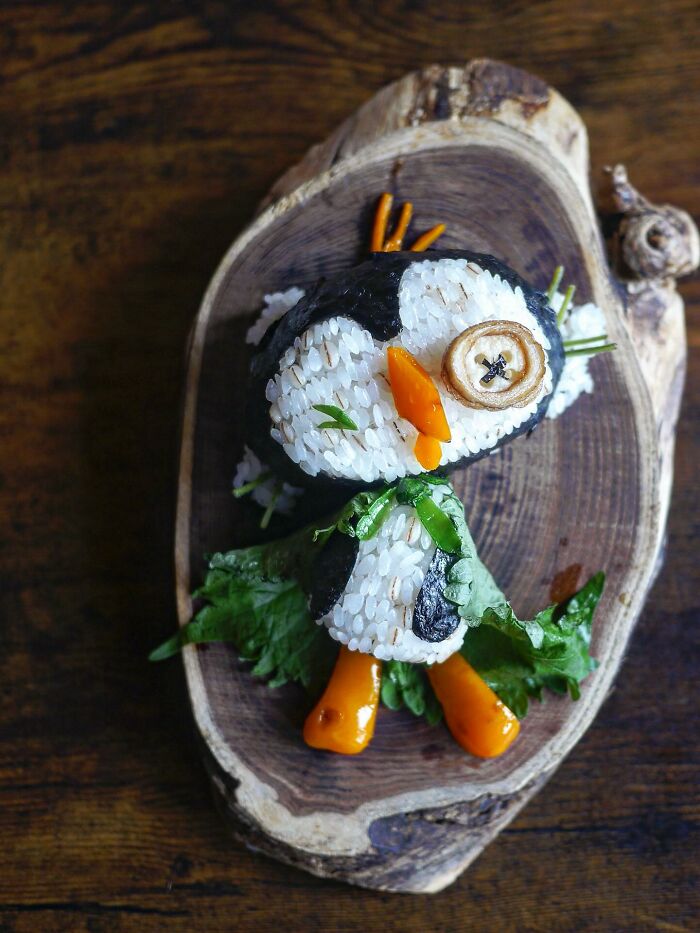 Creative meal shaped like a penguin made of rice, seaweed, and vegetables by a mom from Japan for her kids.