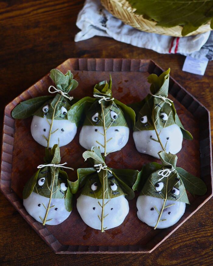 Creative meals by a mom in Japan, featuring cute edible treats wrapped in leaves with playful faces.