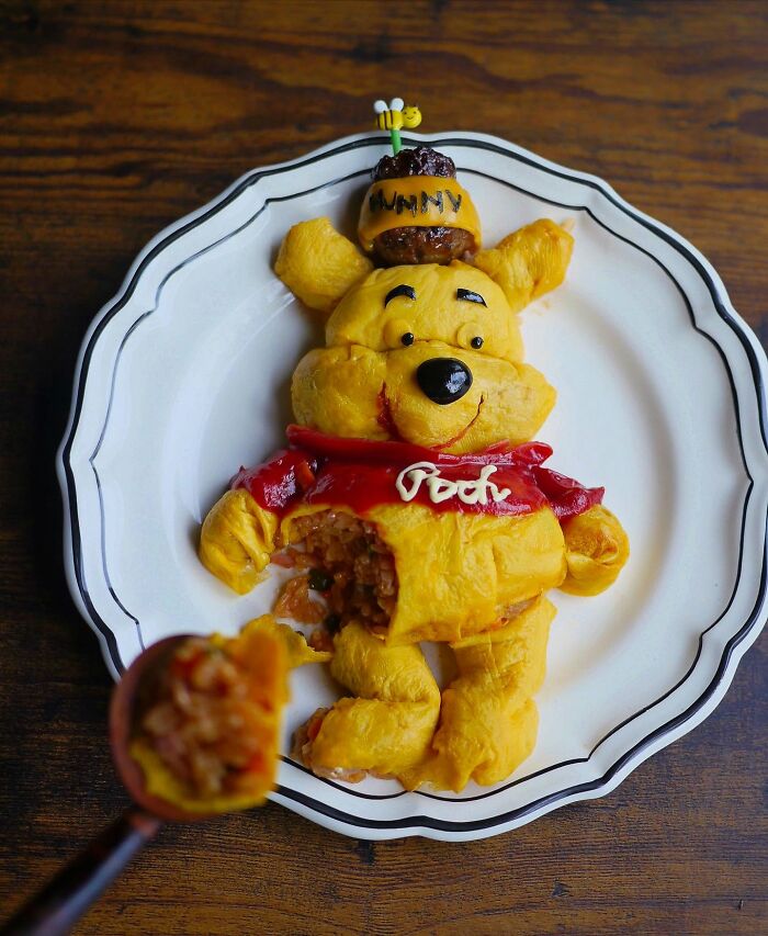 Creative meals for kids from Japan featuring a detailed Winnie the Pooh-shaped rice and omelette dish on a white plate.