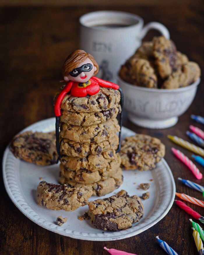 Creative meals for kids featuring a chocolate chip cookie tower with a small superhero figure on top on a white plate.
