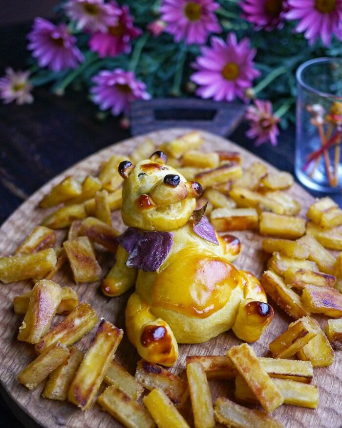 Creative meal shaped like a bear with fries on a wooden board, showcasing a mom from Japan's inventive kids' lunch ideas.