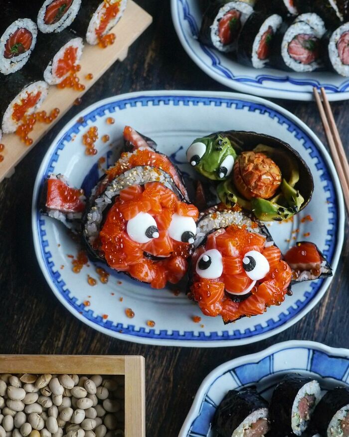 Creative Japanese sushi meals shaped like cartoon fish with expressive eyes on a decorated plate for kids' lunch.