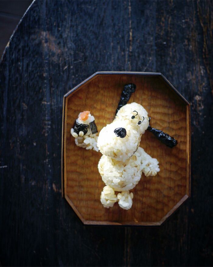 Creative meals by a mom from Japan featuring a character-shaped rice sculpture with seaweed details on a wooden plate.