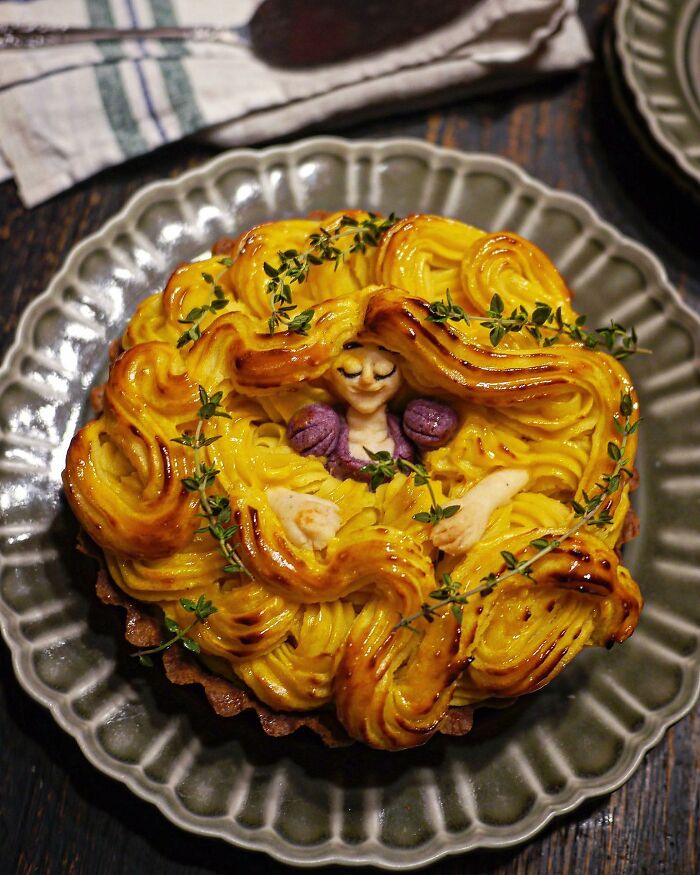 Creative meal by Japanese mom featuring a detailed edible figure with vibrant yellow and purple frosting on a decorative plate.