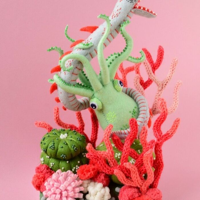 Colorful and weird felted artworks featuring a green squid and coral-like structures on a pink background.