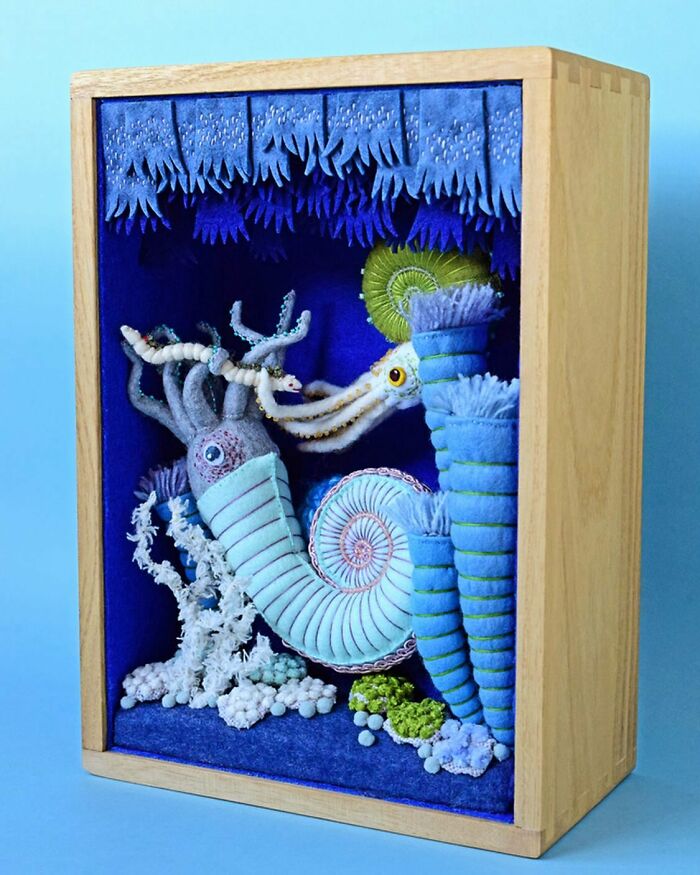 Felted artworks of sea creatures in a wooden box, featuring detailed and colorful felted marine life scenes.