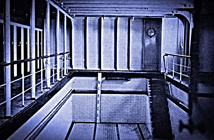 Empty indoor swimming pool on the Titanic with depth markings captured in rare historical photos of the ship.