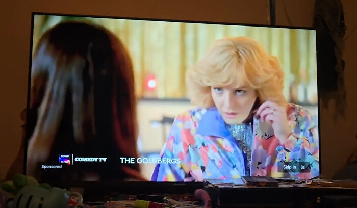 A scene from a TV show playing on a screen in a dimly lit room, illustrating real-life dystopian scenes in the US.