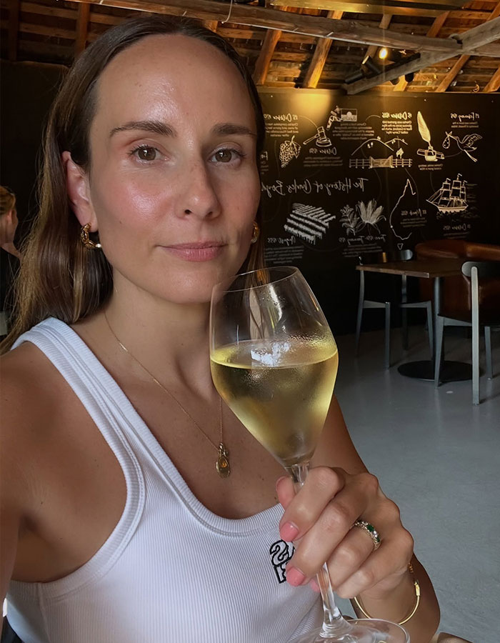 Woman holding wine glass at pub highlighting double standards in dress code and covering up policies.