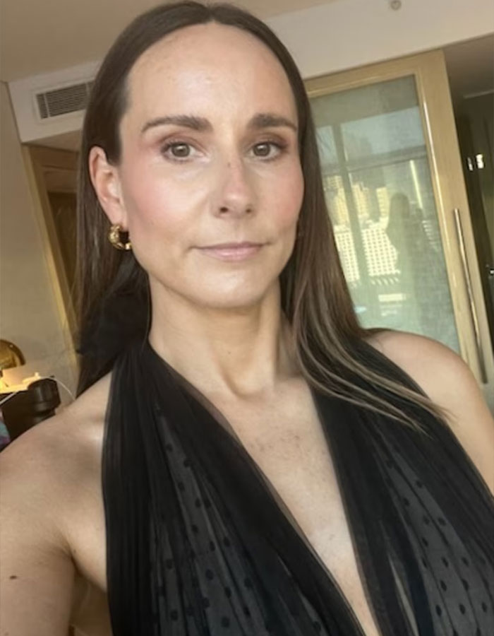 Woman wearing a black dress at home exposing double standards after being told to cover up at pub looking confident.