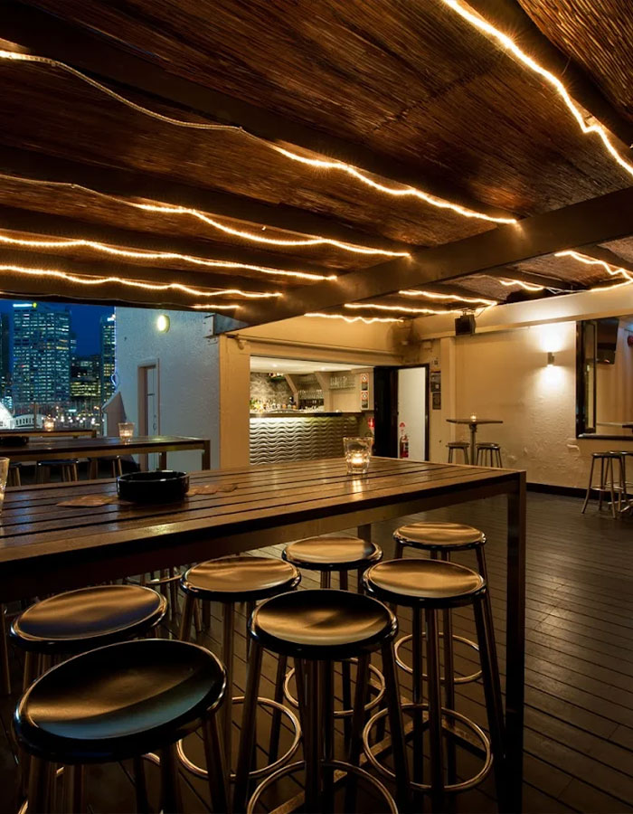 Cozy pub interior at night with bar stools and ambient lighting, reflecting social double standards in woman cover up discussions.