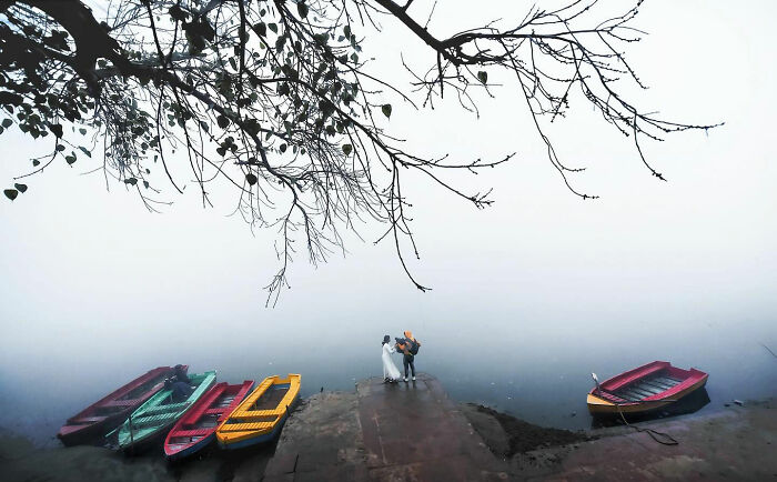 Couple standing on a dock surrounded by colorful boats, captured as a candid moment of everyday life in Istanbul.