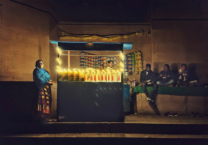 Street vendor and people captured in a candid moment of everyday life in Istanbul during nighttime.
