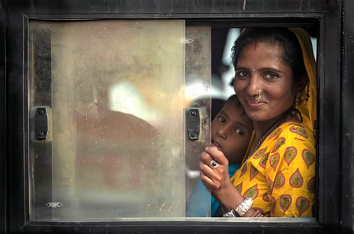 Woman and child sharing a candid moment through a window, capturing everyday life in Istanbul with vibrant colors and expressions.