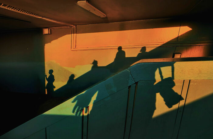 Shadows of people walking on stairs during golden hour, capturing candid moments of everyday life in Istanbul.